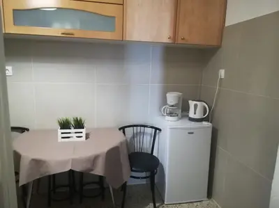 a small kitchen with a table and a small refrigerator at Unique 3 BDRM apartment, 5 min walk from Acropolis in Athens