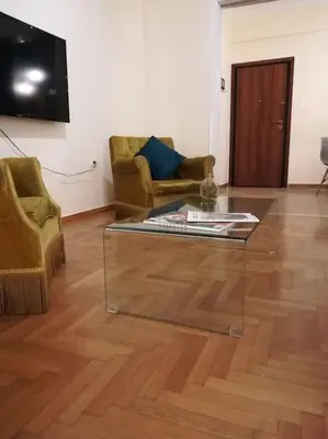 a living room with a glass coffee table and two chairs at Unique 3 BDRM apartment, 5 min walk from Acropolis in Athens