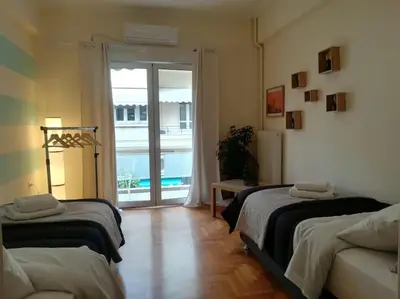 a bedroom with two beds and a sliding glass door at Unique 3 BDRM apartment, 5 min walk from Acropolis in Athens