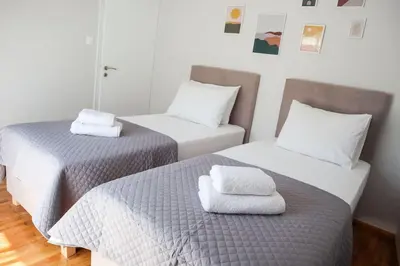 two beds with towels on top of them in a room at Modern Top Floor Apt, 5min to Acropolis & Plaka in Athens