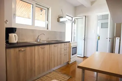a kitchen with wooden cabinets and a sink and a table at Modern Top Floor Apt, 5min to Acropolis & Plaka in Athens