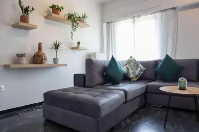 a living room with a gray couch and a table at Modern Top Floor Apt, 5min to Acropolis & Plaka in Athens