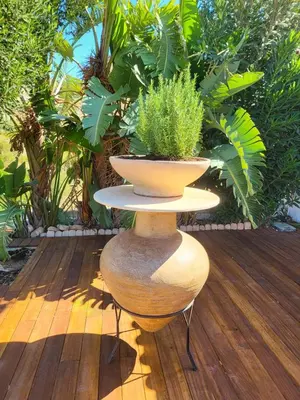 a plant on a stand on a wooden deck at Villa Solaris in Sounio