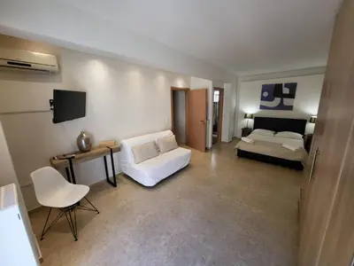 a living room with a white couch and a bed at Villa Solaris in Sounio
