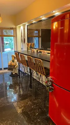 a kitchen with a bar with chairs and a red refrigerator at Sarakin's Mansion Luxury Retreat in Athens