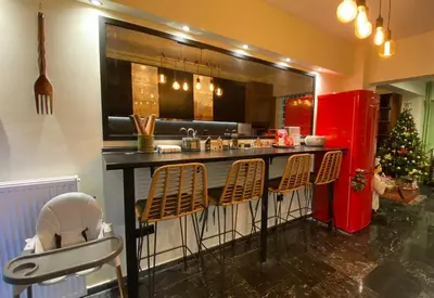 a kitchen with a bar with chairs and a christmas tree at Sarakin's Mansion Luxury Retreat in Athens