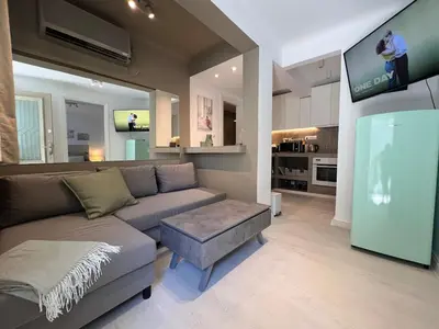 a living room with a couch and a flat screen tv at Diegos cozy Athens Apartment Walk to Acropolis in Athens