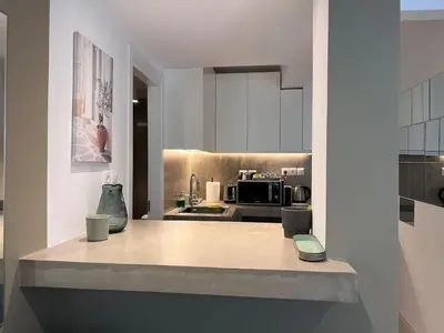 a kitchen with white cabinets and a counter top at Diegos cozy Athens Apartment Walk to Acropolis in Athens