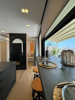 a room with a kitchen with a counter and chairs at BlueMotion - PortSuite 5B in Piraeus
