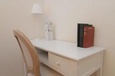 a white desk with a book and a chair at Acropolis Hill House in Athens