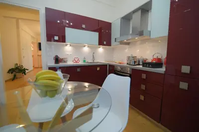 a kitchen with purple cabinets and a glass table at Acropolis Hill House in Athens