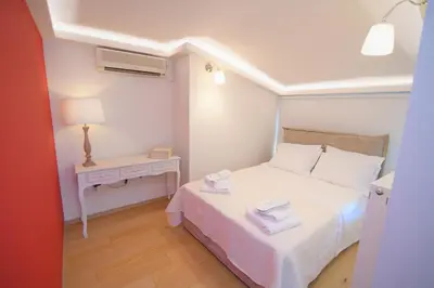 a small bedroom with a white bed and a table at Acropolis Hill House in Athens