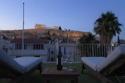 a table with a bottle of wine and a glass at Acropolis Hill House in Athens