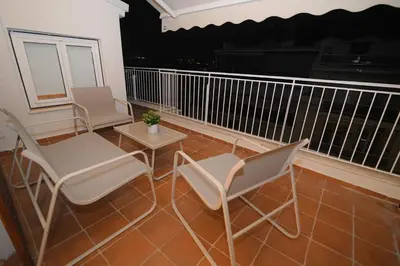 two chairs and a table on a balcony at night at Acropolis Hill House in Athens