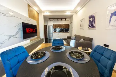 a living room with a table and blue chairs at Polis luxury apartment 4 in Athens