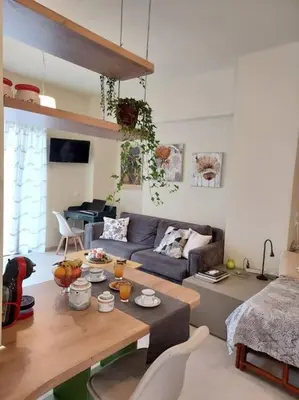 a living room with a couch and a table at Sunny studio near metro in Athens