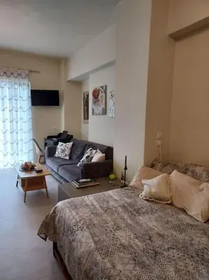 a bedroom with a large bed and a couch at Sunny studio near metro in Athens