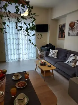 a living room with a blue couch and a table at Sunny studio near metro in Athens
