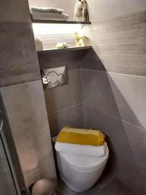 a bathroom with a toilet with a yellow towel on it at Sunny studio near metro in Athens