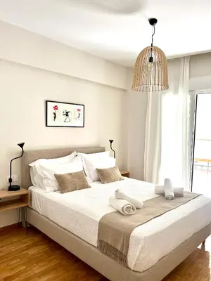 a white bedroom with a large bed with towels on it at CK Athens Fine Stay Apartments - Lux & Modern - 2 min from Metro in Athens