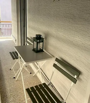 a table and a chair next to a wall at CK Athens Fine Stay Apartments - Lux & Modern - 2 min from Metro in Athens