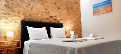 a bedroom with a bed with towels on it at Stone Apartment Close to the Airport in Spáta