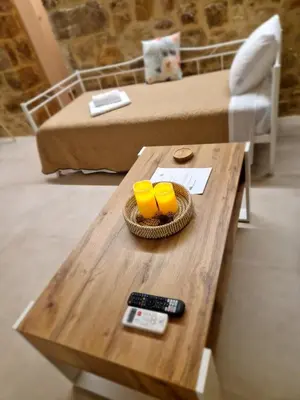 a coffee table with two yellow cups and a remote control at Stone Apartment Close to the Airport in Spáta