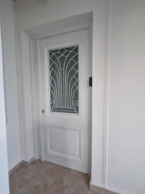 a white door with a pattern on it in a room at Stone Apartment Close to the Airport in Spáta