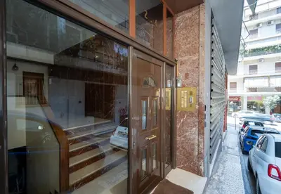 a building with a revolving door on a street at LIV - Comfortable & Stylish Escape in Pagrati in Athens