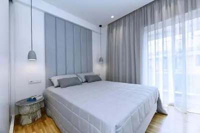 a bedroom with a large bed and a large window at Zana's cozy Apartment at Glifada in Athens