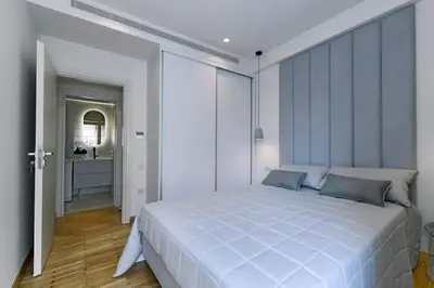 a bedroom with a large white bed and a hallway at Zana's cozy Apartment at Glifada in Athens