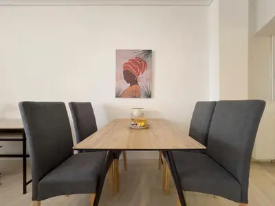 a dining room with a wooden table and chairs at NAGIA Modern Apt Paleo Faliro B-1 in Athens