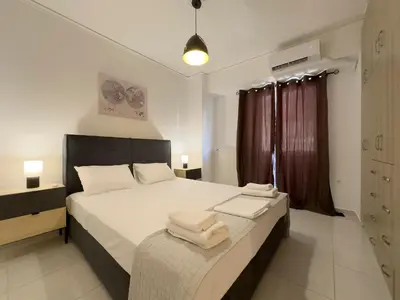 a bedroom with a large bed with towels on it at NAGIA Modern Apt Paleo Faliro B-1 in Athens