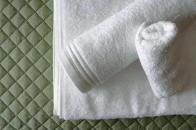 a white towel sitting on top of a bed at Ampa's Home in Athens