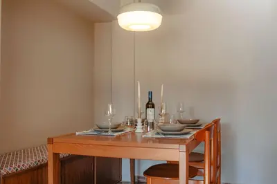 a dining room table with a bottle of wine on it at Ampa's Home in Athens