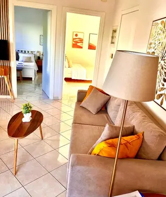 a living room with a couch and a lamp at Mesogaia Home Near ATH Airport in Markopoulo