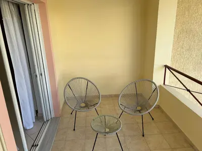 two chairs and a table in a room at Mesogaia Home Near ATH Airport in Markopoulo