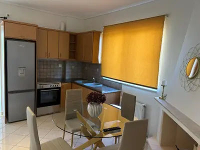 a kitchen with a table and chairs in a kitchen at Mesogaia Home Near ATH Airport in Markopoulo