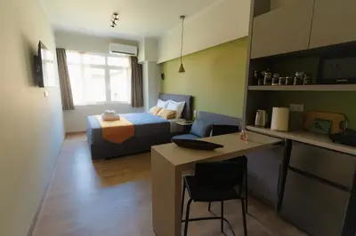 a living room with a bed and a kitchen with a table at Livelula apartment in Athens