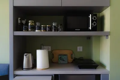 a kitchen with a shelf with a microwave and a coffee maker at Livelula apartment in Athens