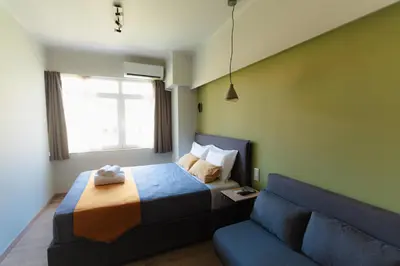 a bedroom with a bed and a couch at Livelula apartment in Athens