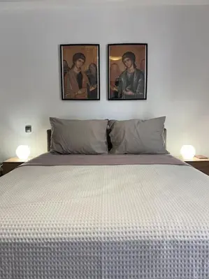a bedroom with a bed with three pictures on the wall at Piano Quiet Apartment Garden in Athens