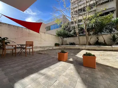 a patio with a table and chairs in front of a building at Piano Quiet Apartment Garden in Athens