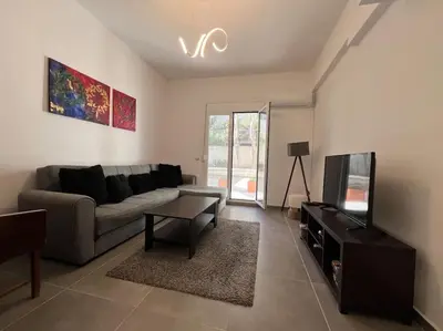 a living room with a couch and a tv at Piano Quiet Apartment Garden in Athens