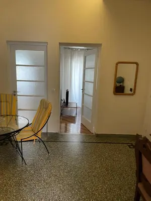 a dining room with a table and chairs and a mirror at Quiet just renewed apartment in Neapolis in Athens
