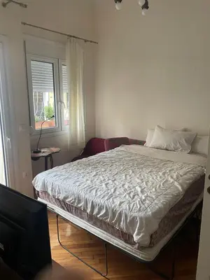 a large bed in a room with a window at Quiet just renewed apartment in Neapolis in Athens