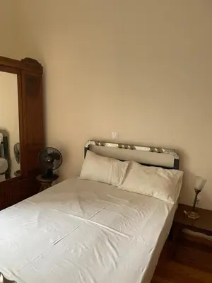 a bedroom with a white bed with a headboard at Quiet just renewed apartment in Neapolis in Athens