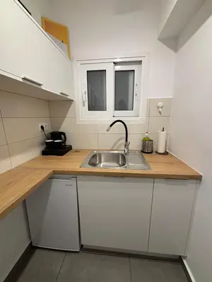 a kitchen with a sink and a wooden counter top at TINY STUDIOS Under the Akropolis -2- in Athens