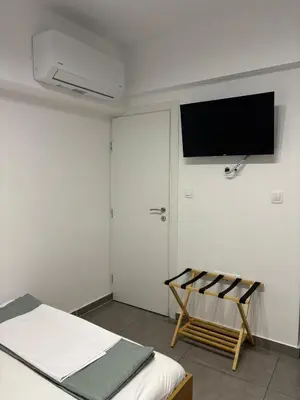 a bedroom with a bed and a flat screen tv on the wall at TINY STUDIOS Under the Akropolis -2- in Athens