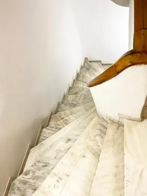 a staircase with marble floors and a white wall at TINY STUDIOS Under the Akropolis -2- in Athens